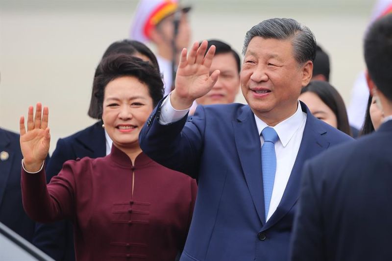 El presidente chino, Xi Jinping (D), y su esposa, Peng Liyuan (I), aludan al llegar al aeropuerto internacional de Noi Bai,en Hanoi. EFE/EPA/LUONG THAI LINH / POOL 01 121223