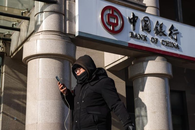 Un hombre pasa frente a un banco en Pekín, China, el 20 de diciembre de 2024. EFE/EPA/WU HAO